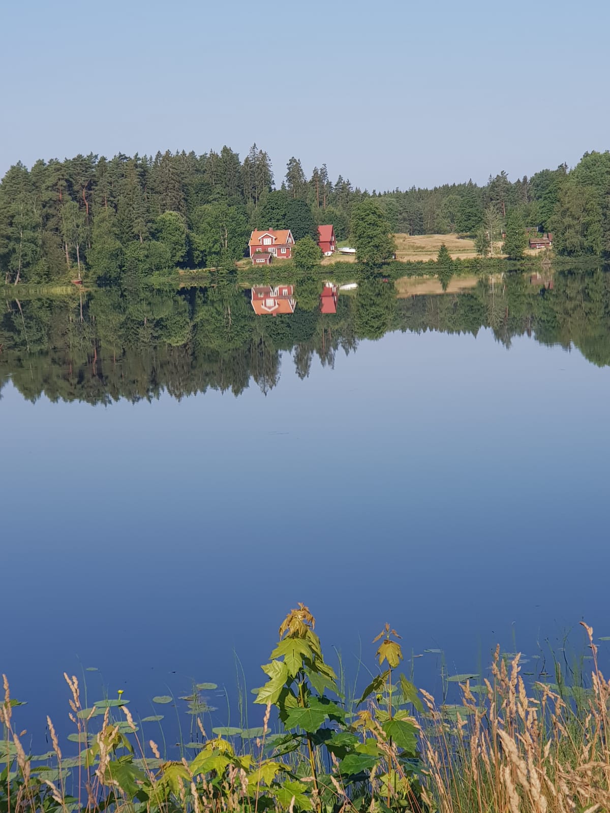 Ein See mit einem roten Haus am Seeufer